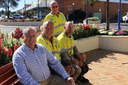 Bigger view of Sitting in one of the flower-filled spaces they’ve created are: (L to R) Matthew Robertson (Parks and Open Space Coordinator), Harry Mager (Parks and Open Space Ganger), Craig Lewington(Parks and Open Space Ganger) and standing, Kevin Sheppard (Parks and Open Space Supervisor).